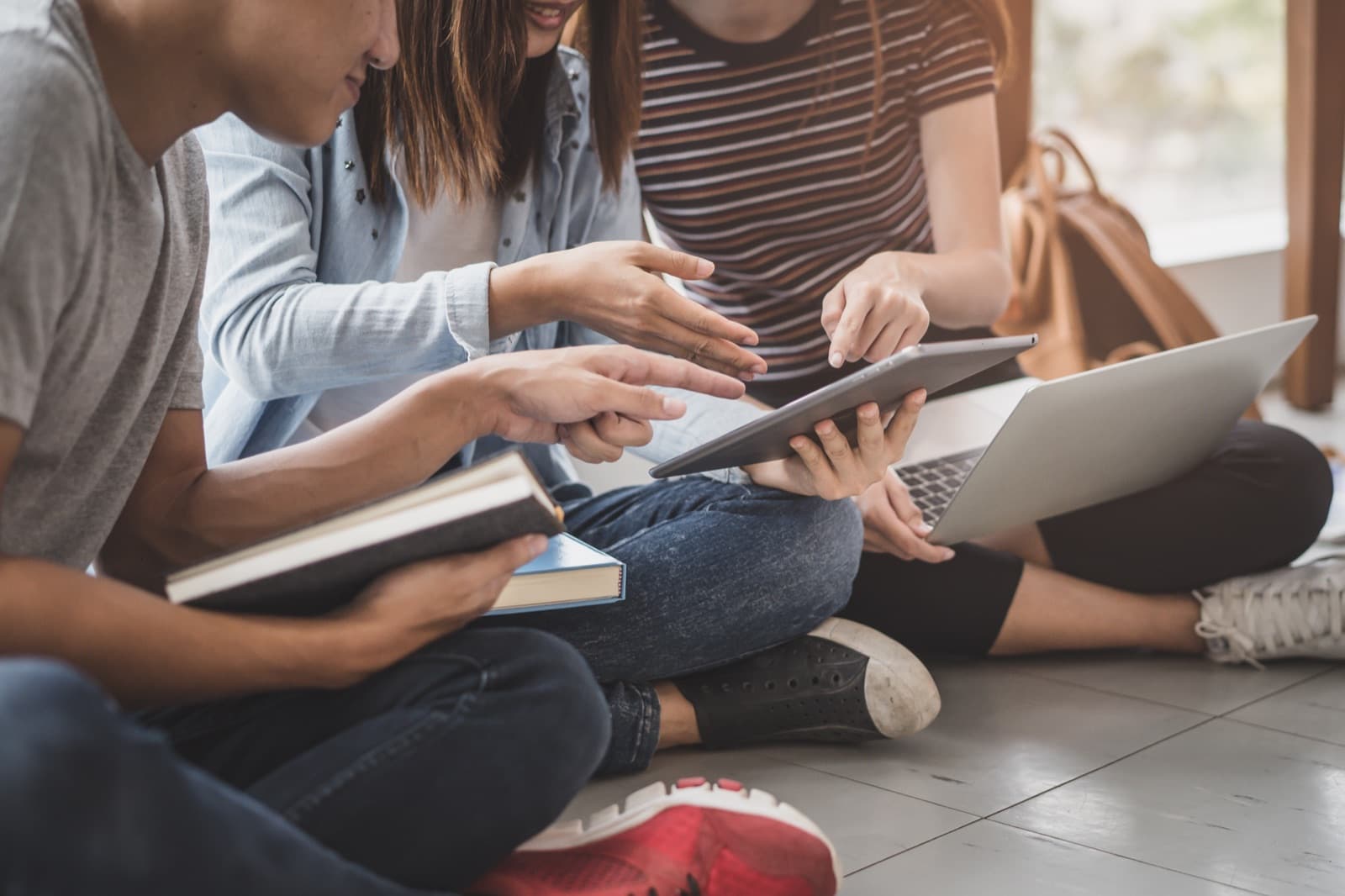 Students studying together with books and devices