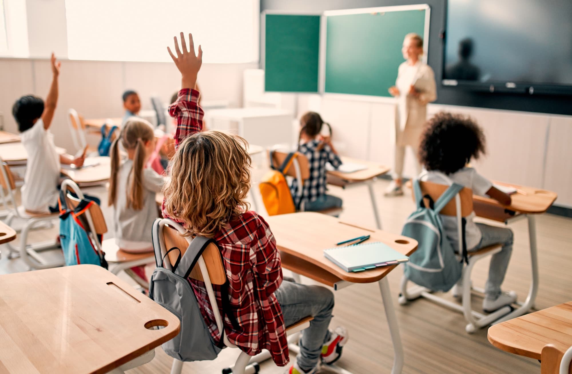 Students raising their hands in a classroom